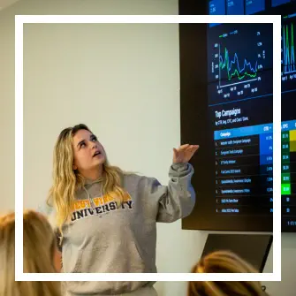 Student pointing to Google Ads analytics on screen